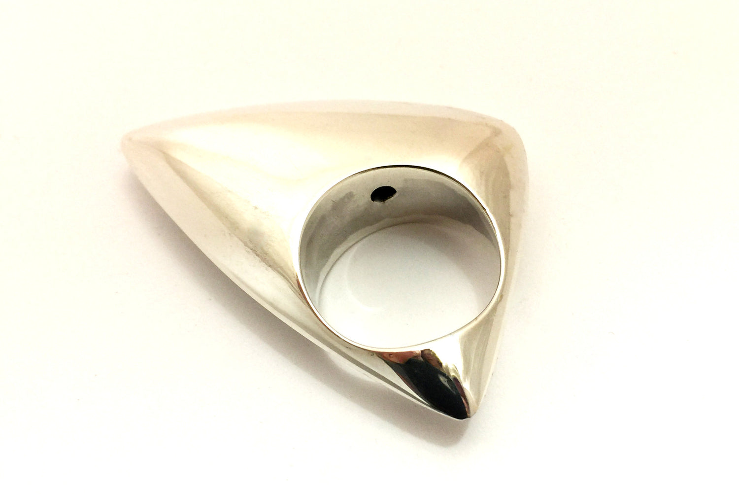 Triangular shaped hollow formed ring with curved edges and shiny finish.