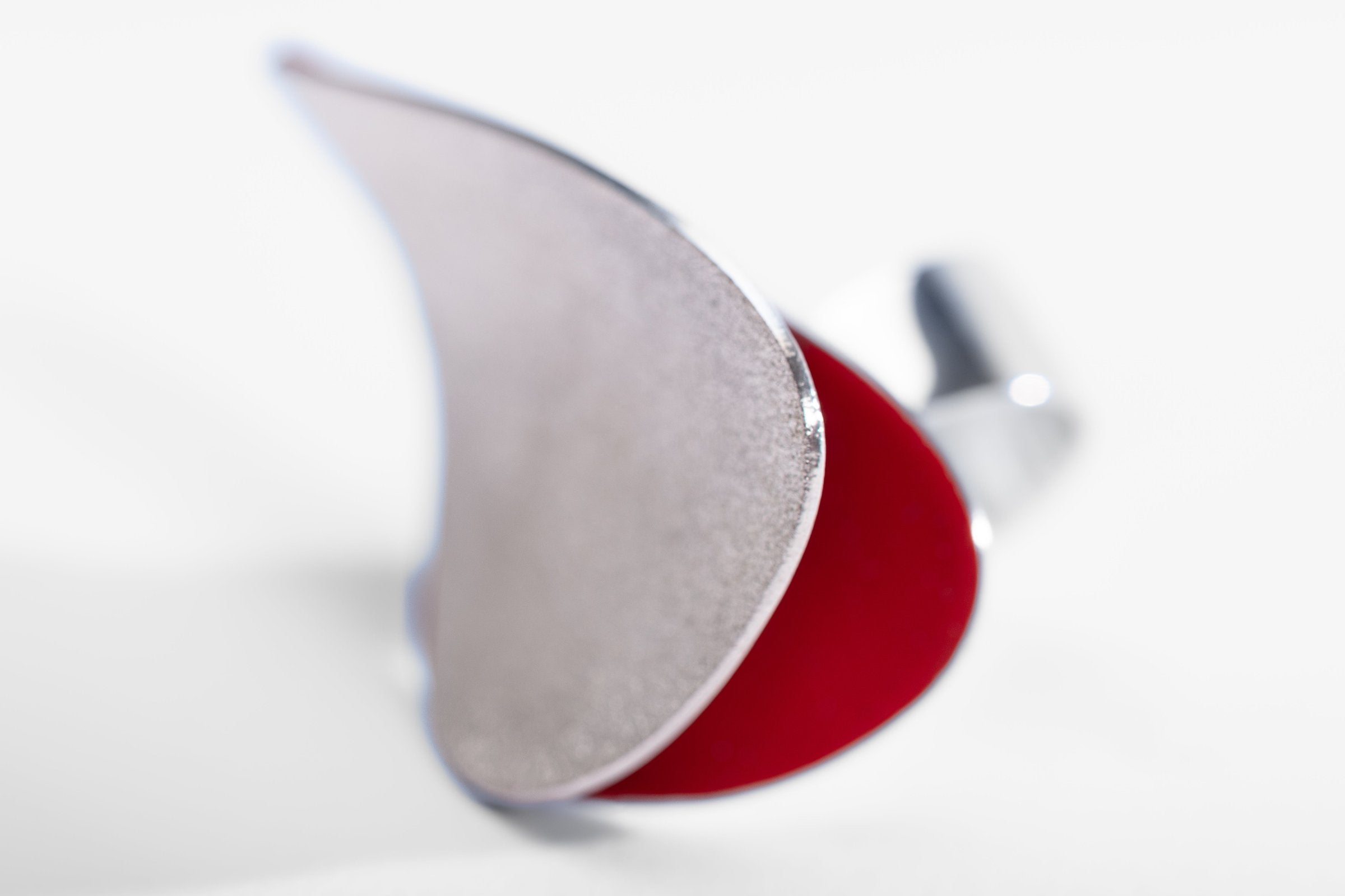 Contemporary silver ring with red enamel interior in a wave-like shape.